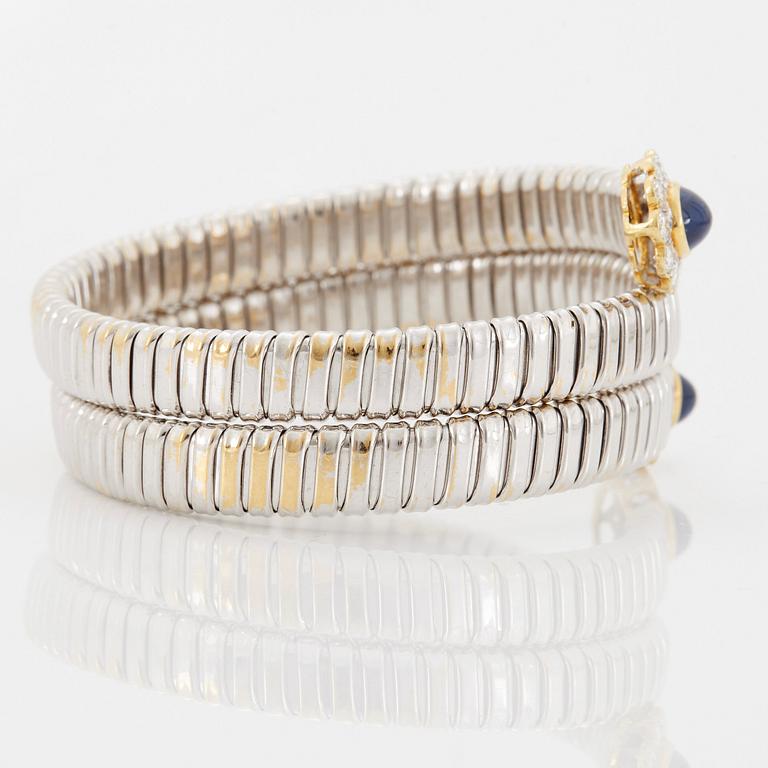 An 18K gold bangle set with cabochon-cut sapphires and round brilliant-cut diamonds.