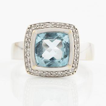 Ring in 18K white gold with a faceted topaz and round brilliant-cut diamonds.