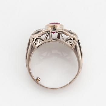 An 18K white gold ring set with a faceted ruby and round brilliant- and eight-cut diamonds.