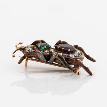 An antique 18K gold beetle brooch set with a faceted emerald and a garnet.