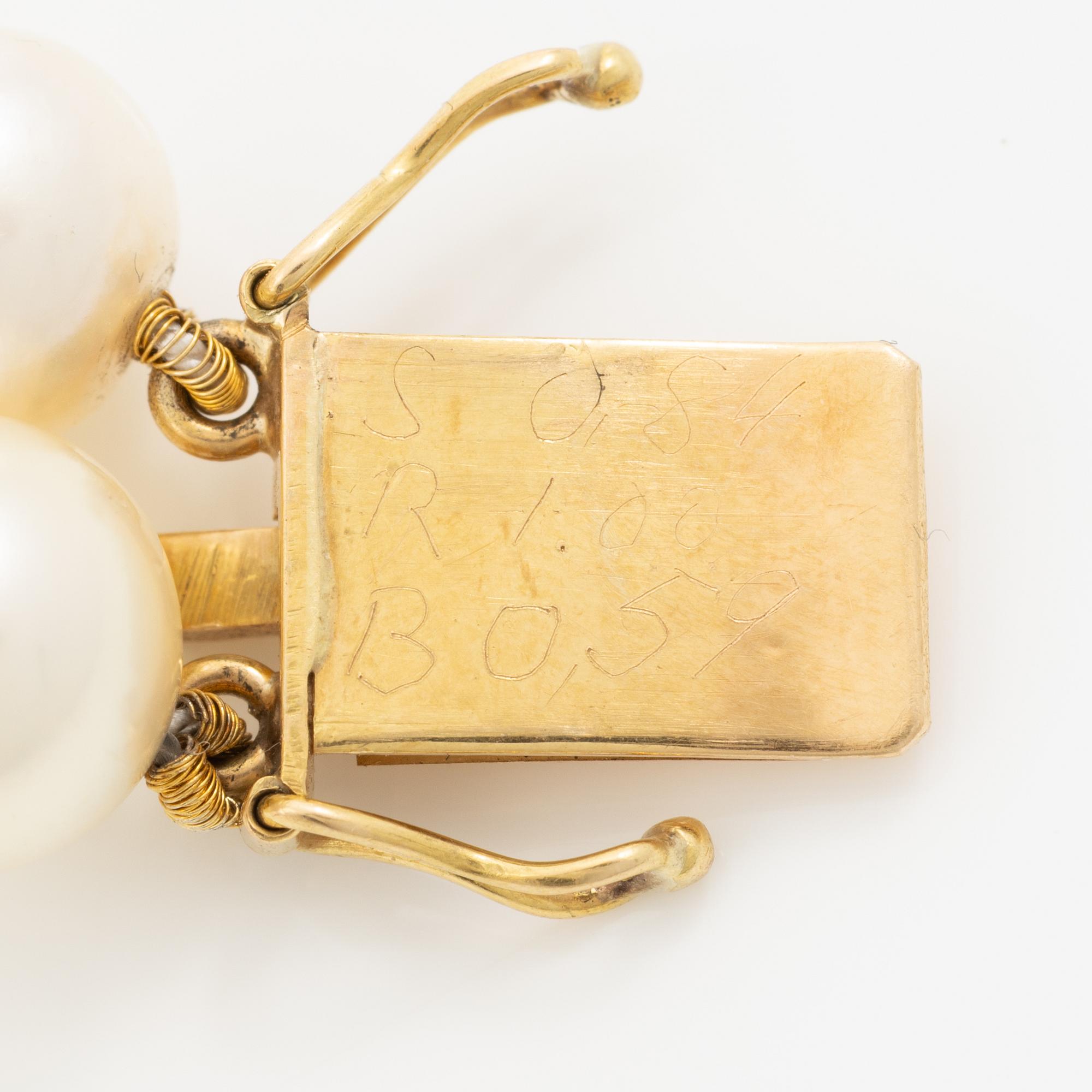 Pearl necklace, two-stranded, with a clasp by Seblings in 18K gold set with emeralds, rubies, and brilliant-cut diamonds.