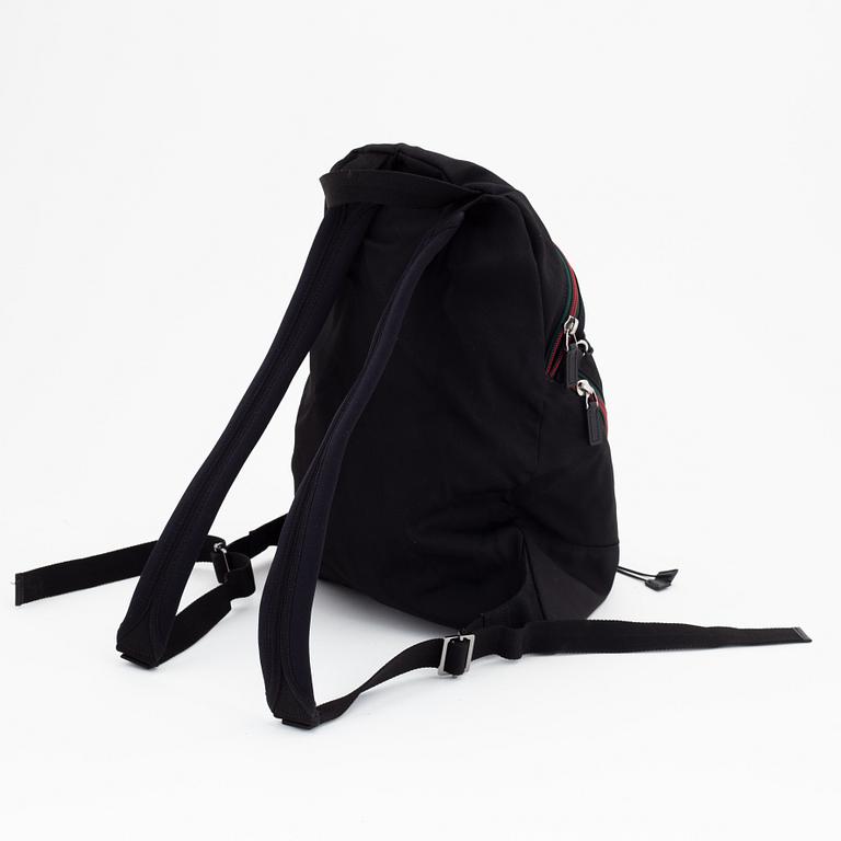 Gucci, a black canvas backpack.
