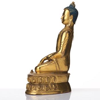 A gilt copper alloy figure of Akhsobya buddha, Tibet, 15th Century.