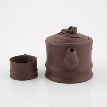 A Chinese yixing ware teapot with four cups, 20th century.