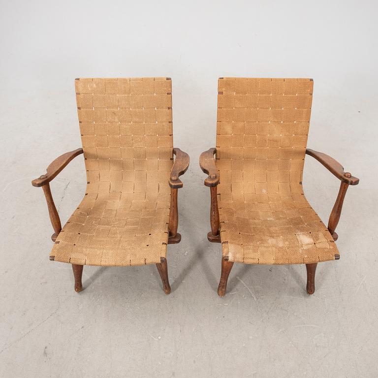 A pair of Swedish Modern pine and saddle-girth easy chairs from the 1940's.