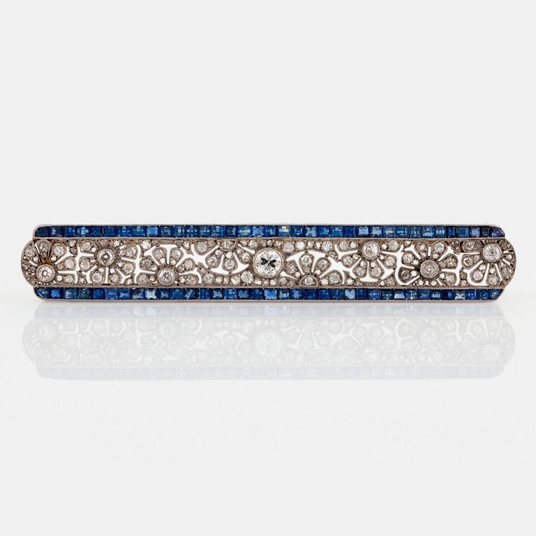 A platinum and gold brooch set with old- and rose-cut diamonds and faceted sapphires.