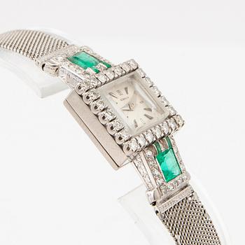 Gübelin bracelet watch in 950 platinum with round brilliant-cut and single-cut diamonds as well as step-cut emeralds.