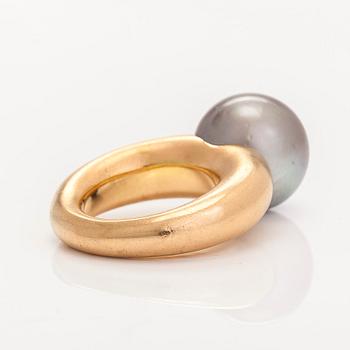 An 18K gold ring, with a cultured Tahiti pearl.