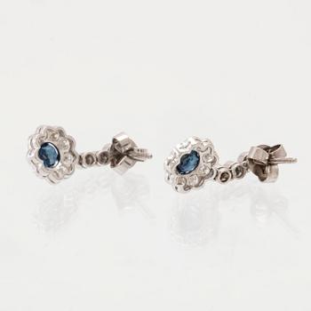 A pair of 18K white gold earring set with sapphires and round brilliant-cut diamonds.