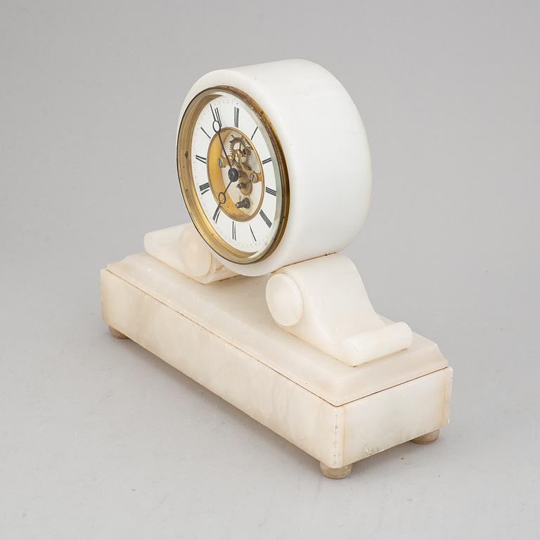 An alabaster mantle clock and pair of candlesticks, circa 1900.
