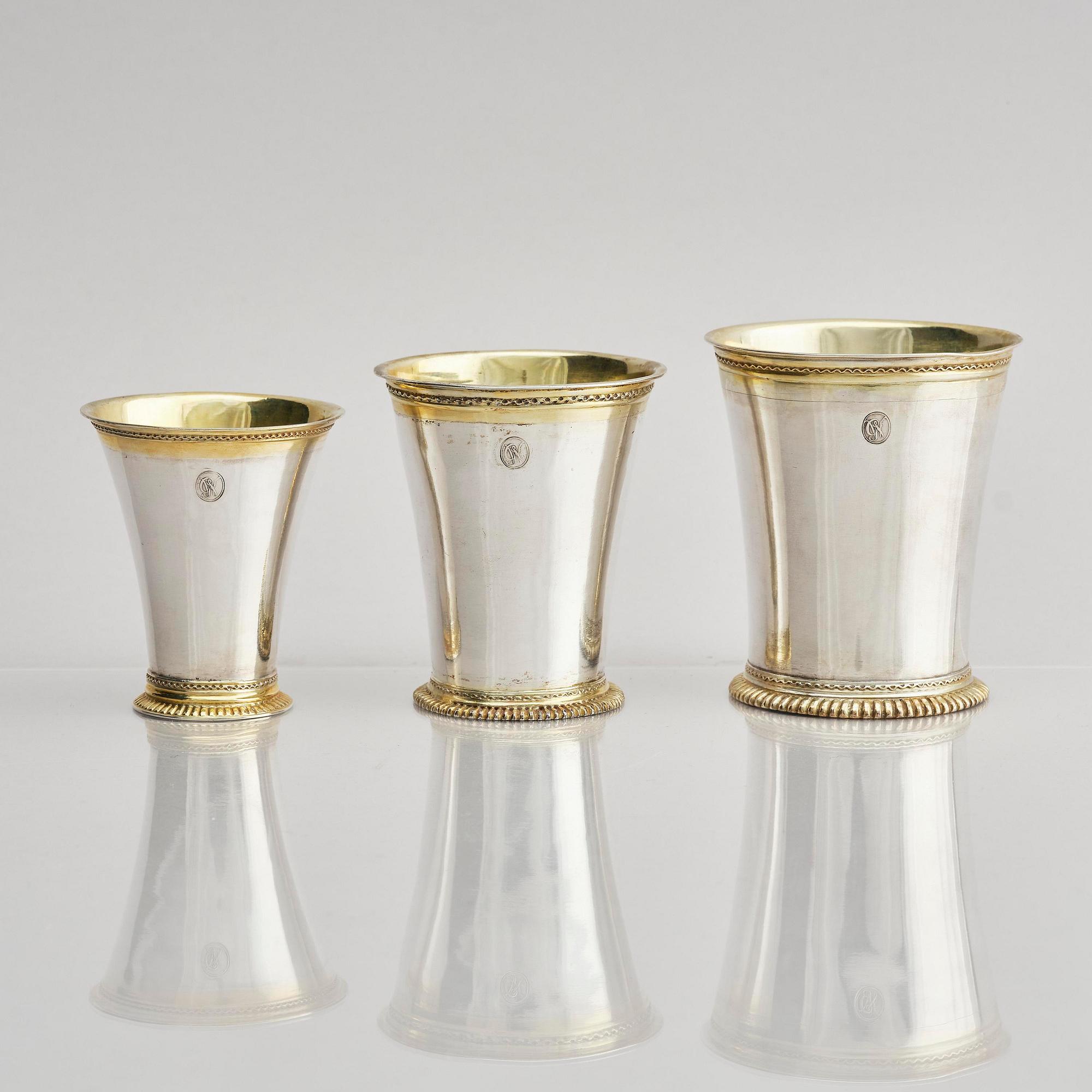 Three Swedish 18th century parcel-gilt silver beakers and a case of birch, different maker's.