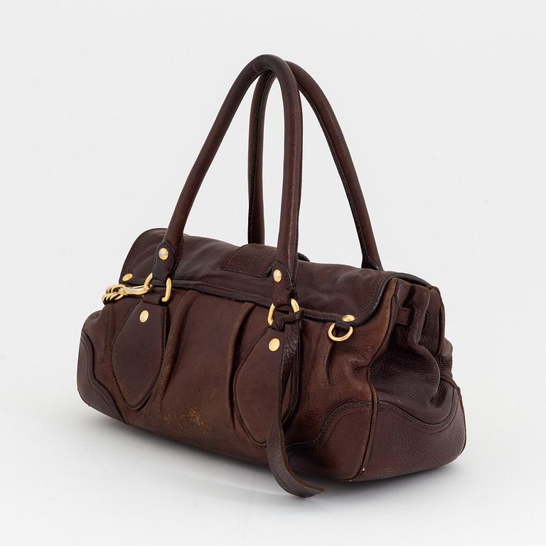 Prada, a brown leather bag.