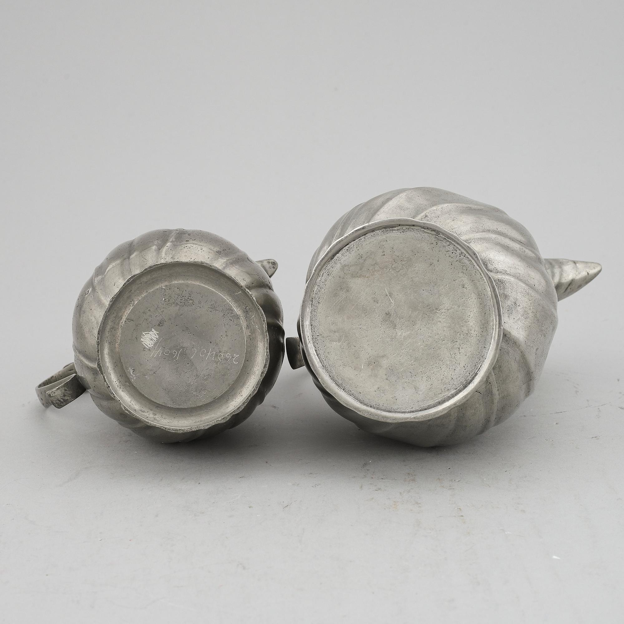 A pair of rococo style pewter coffee pots, from around year 1900.