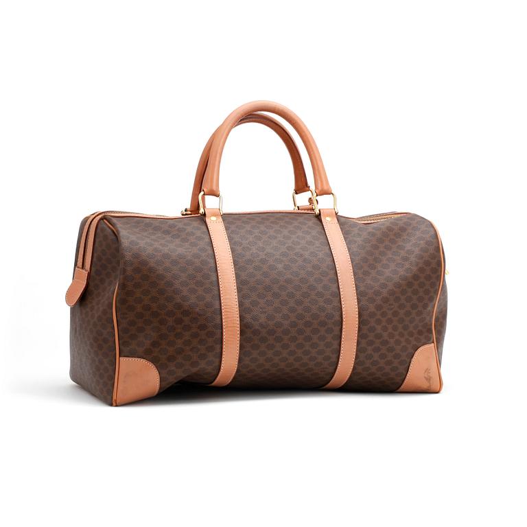 CÉLINE, a brown coated monogram canvas weekend bag.