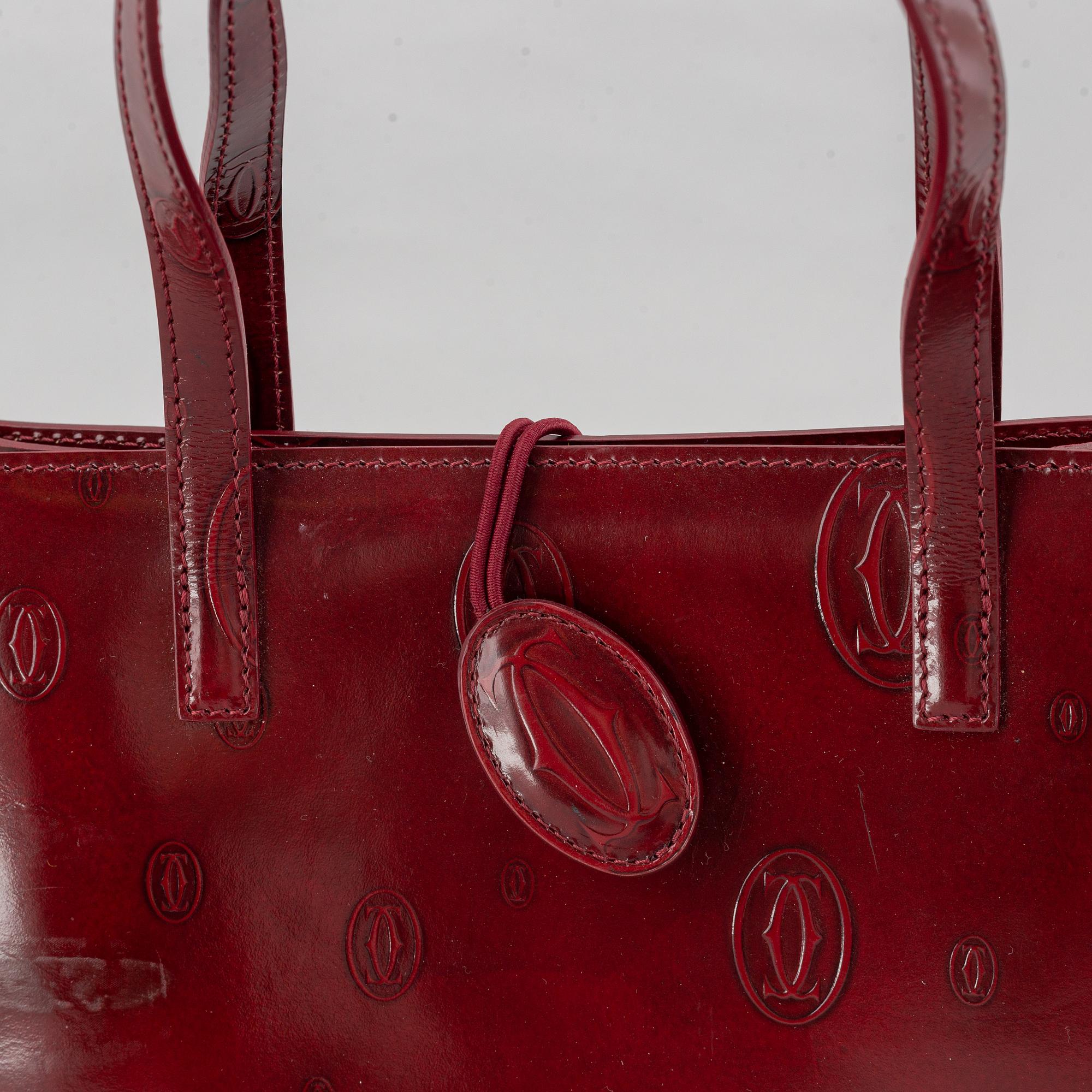 Cartier, a burgundy patent leather handbag and wallet.