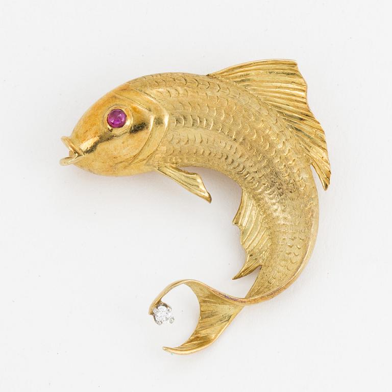 An 18K gold fish brooch set with a diamond and a ruby.