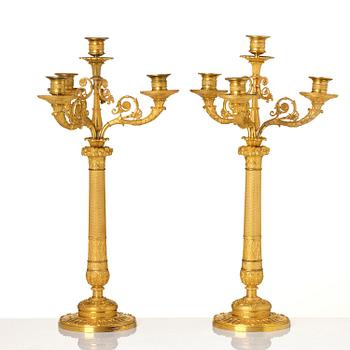 A pair of French Empire four-light gilt bronze candelabra, early 19th century.