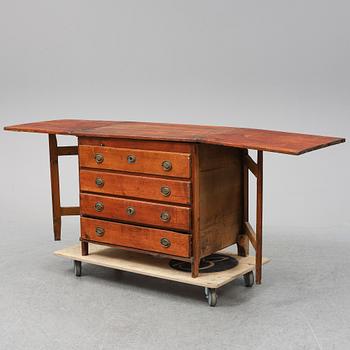 A 19th Century chest of drawers with a table top.