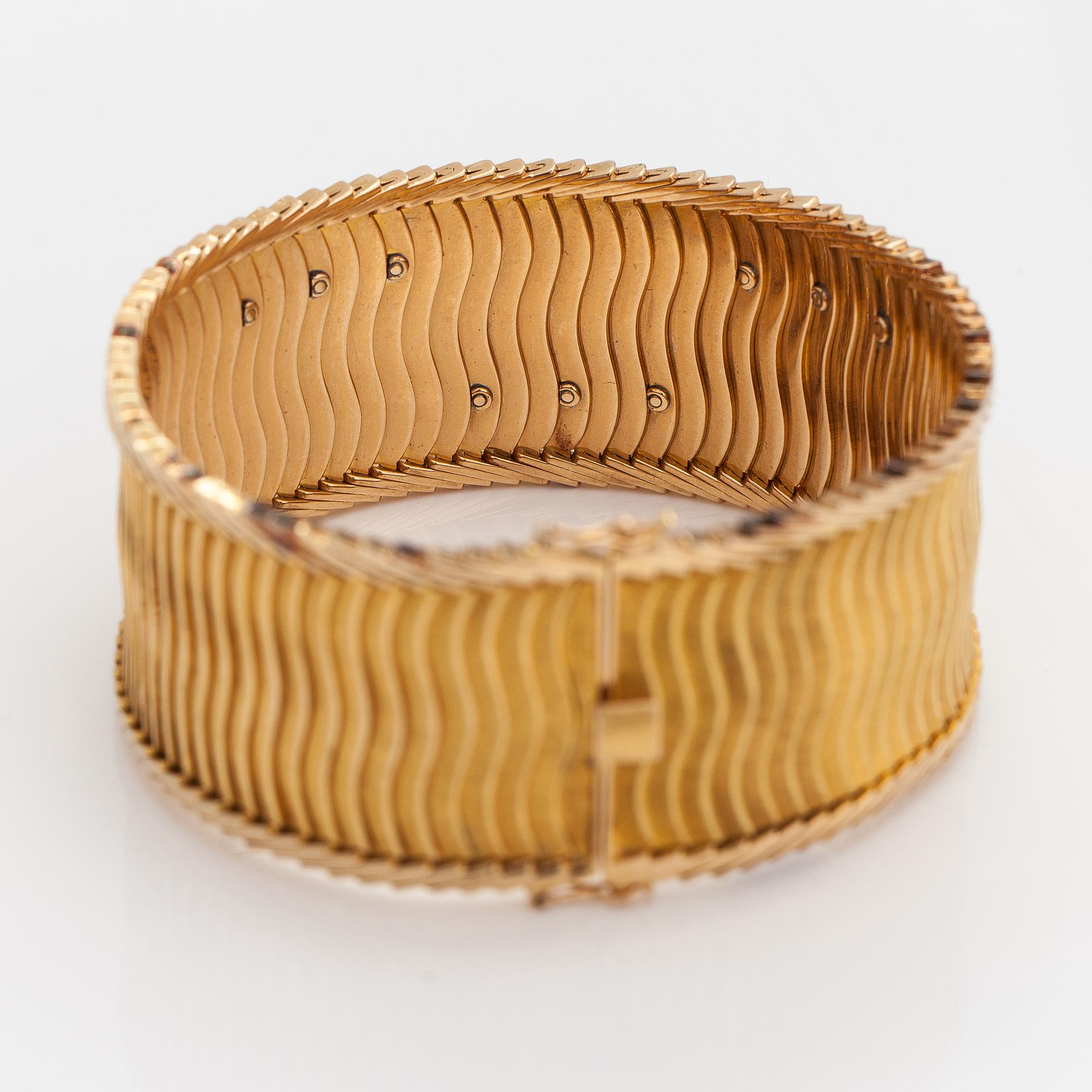 Rannekoru, 18K kultaa, safiireja, samragdi ja timantteja n. 0.075 ct yht. Tuontileimattu Koruteollisuus Tillander 1962.