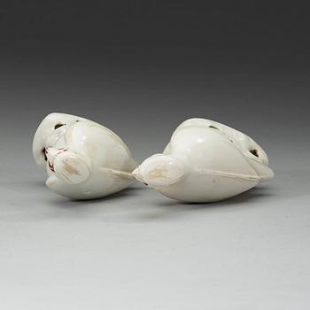 A pair of white and red glazed figures of parrots, late Qing dynasty.