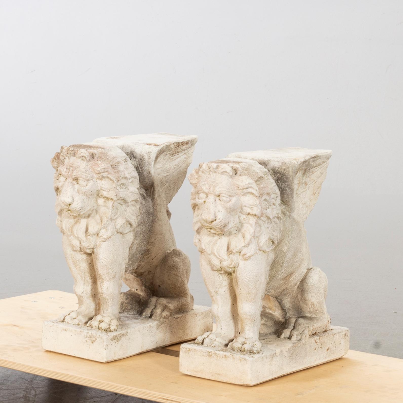 BÄNKUNDERREDE I FORM AV BEVINGADE LEJON, ett par, stenmassa.