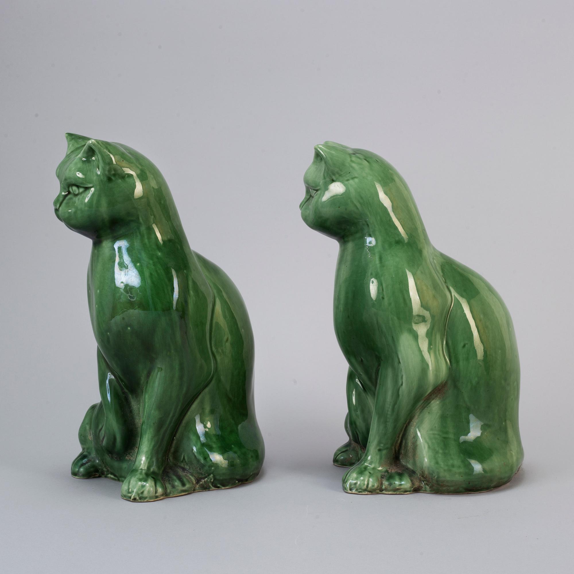 A pair of Chinese green glazed ceramic figurines of cats, 20th century.