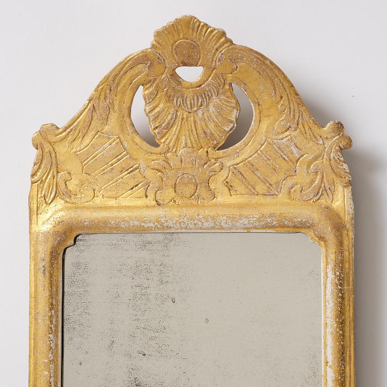 A matched pair of rococo giltwood one-branch girandole mirrors, Stockholm, late 18th century.