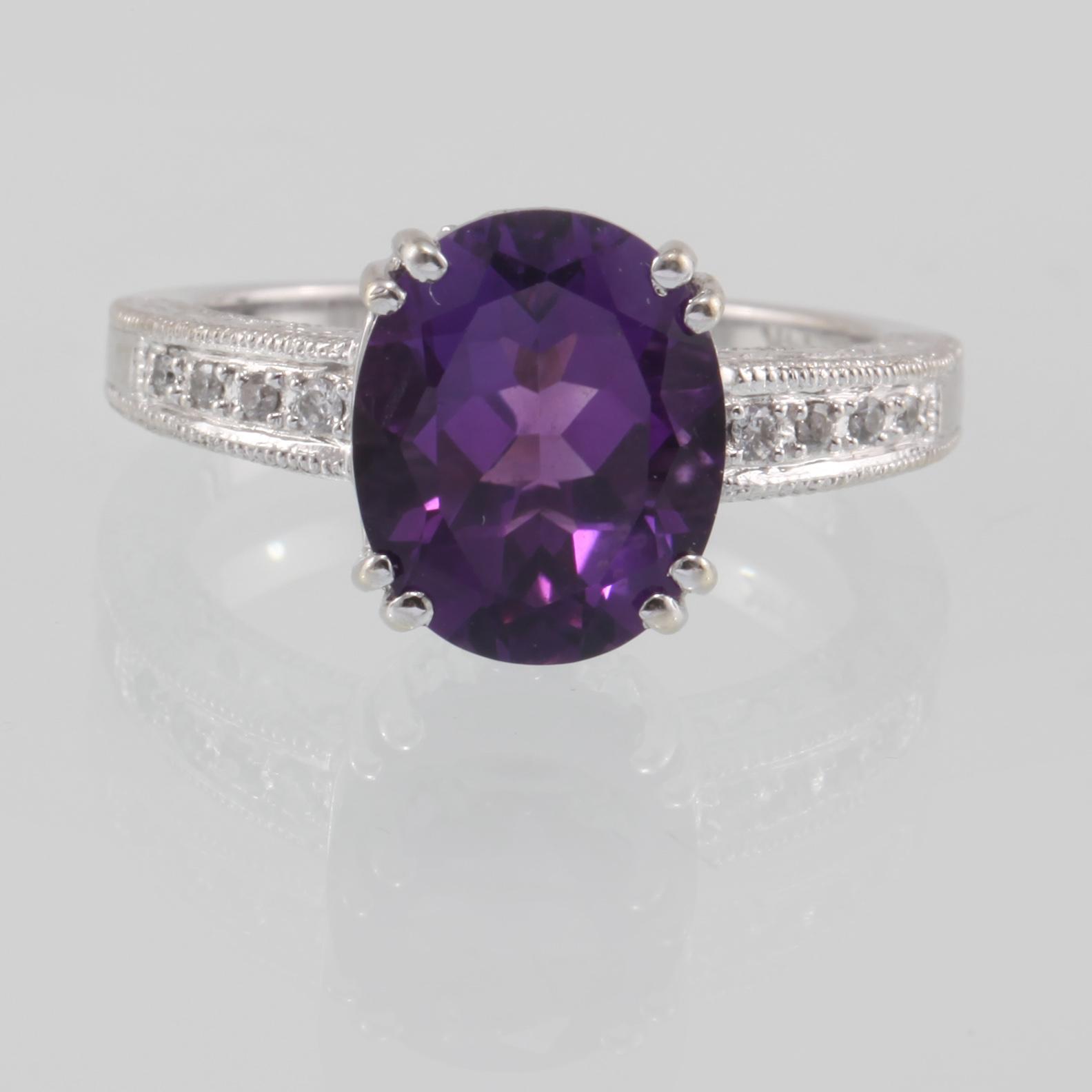 RING, 14K guld med ovalslipad ametist samt åtta briljantslipade diamanter. Vikt 4,6 gram.