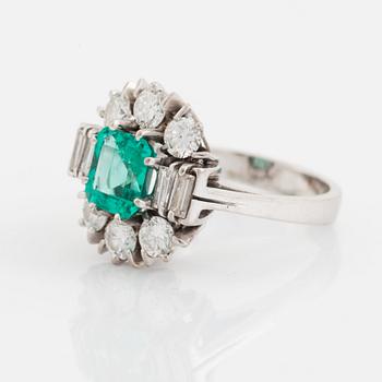 An 18K white gold ring set with a step-cut emerald.