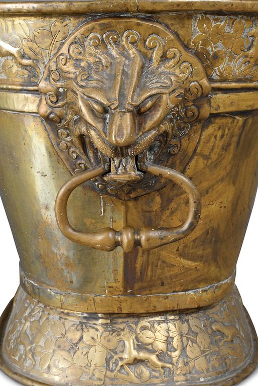 A Baroque brass wine cooler.