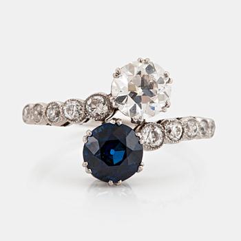 1148A. A platinum ring set with old-cut diamonds and a faceted sapphire.