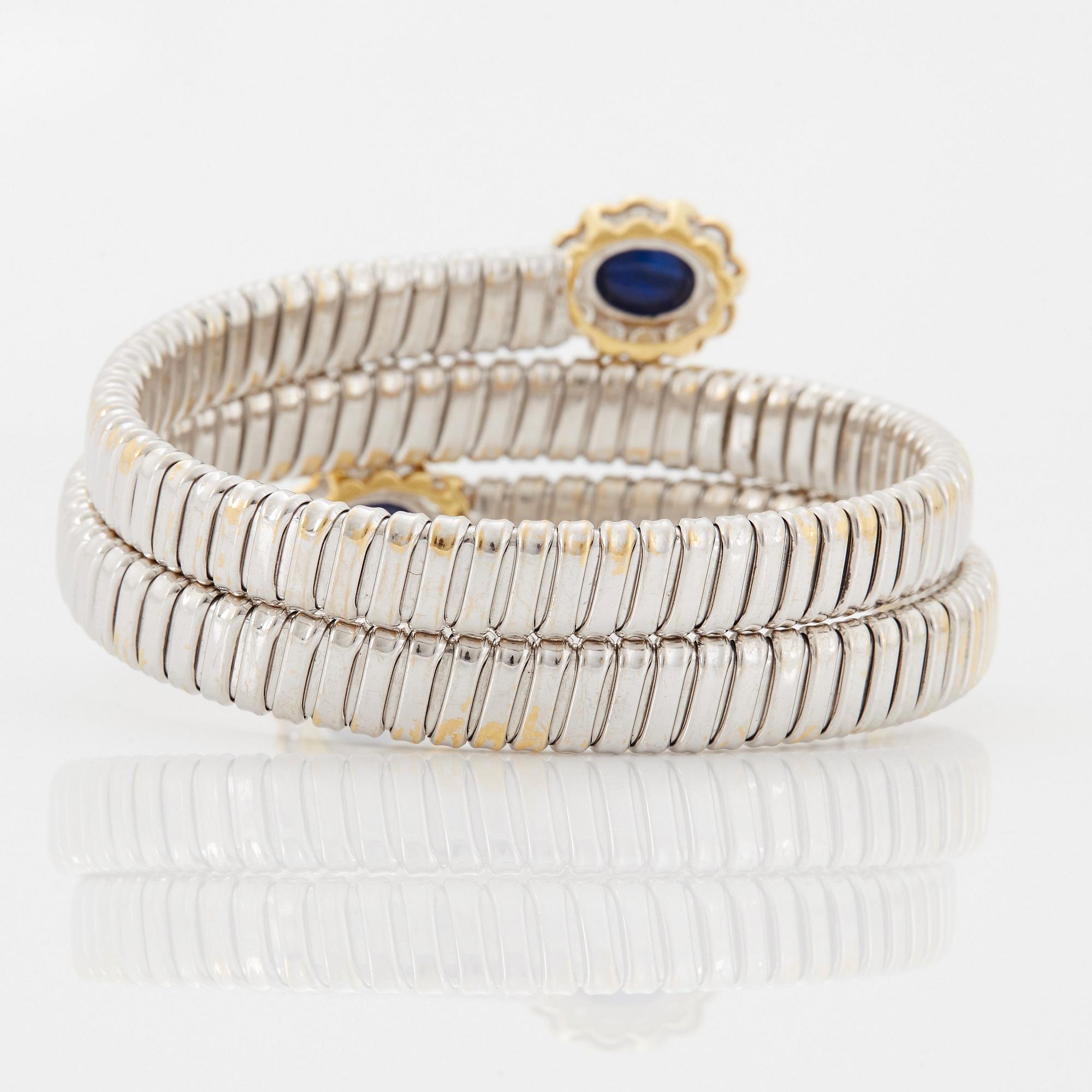 An 18K gold bangle set with cabochon-cut sapphires and round brilliant-cut diamonds.