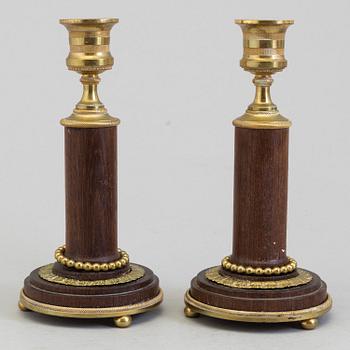 A pair of 20th century mahogany and brass candlesticks.