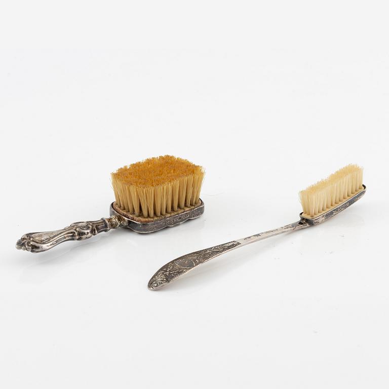Two brushes, a hook, and a small mirror, silver and nickel silver.
