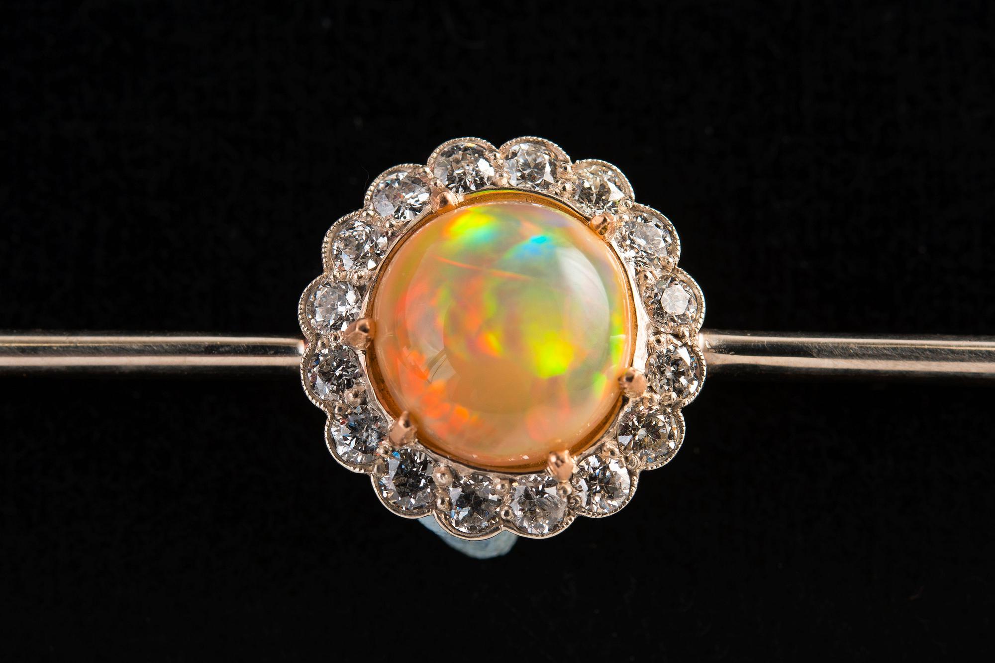 BROSCH, Briljantslipade diamanter ca 0.65 ct, Opal 10 mm.
14K guld. Ostämplad. Längd 85 mm, vikt 8,2 g.