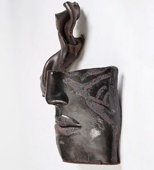 Hertha Hillfon, a black glazed stoneware wall sculpture in two parts of a face and a sky, executed in her own studio, Stockholm 1960s.