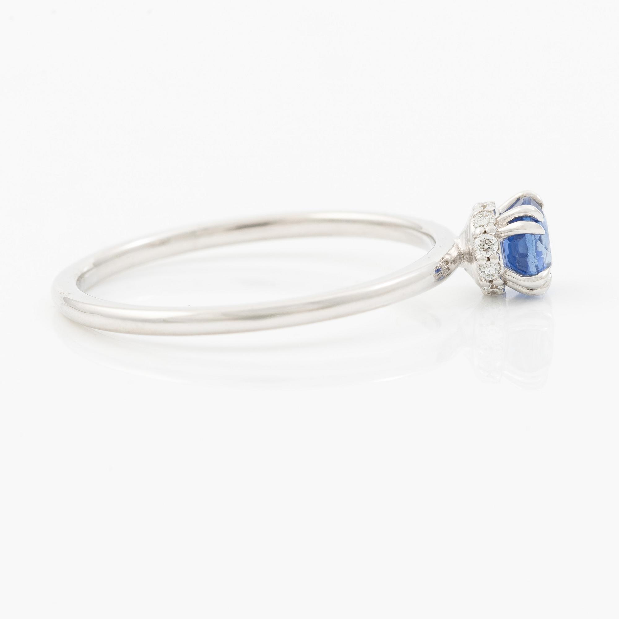 Ring 14K white gold with a sapphire and small brilliant-cut diamonds.