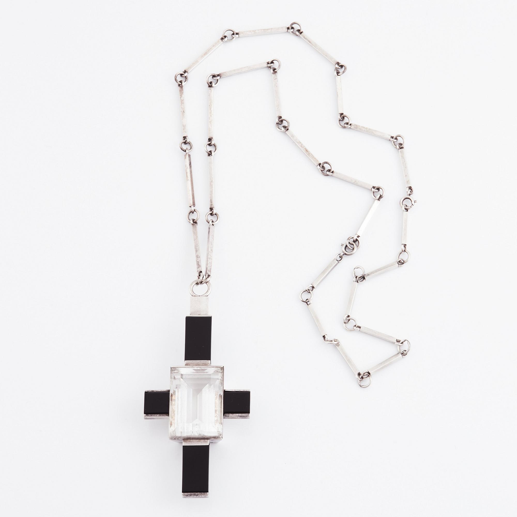 Wiwen Nilsson, hängsmycke i form av ett kors i sterlingsilver med fasettslipad bergkristall och onyx, Lund 1938.