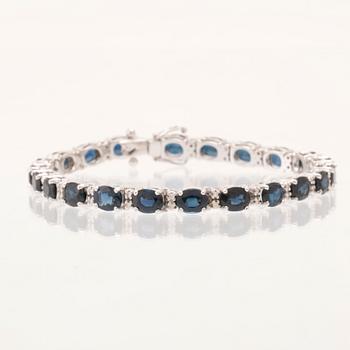 An 18K white gold bracelet set with oval faceted sapphires and round brilliant-cut diamonds.