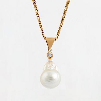 An 18K gold and cultured pearl pendant set with a round brilliant-cut diamond.