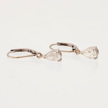 A pair of 18K white gold earrings set with pear cut diamonds.