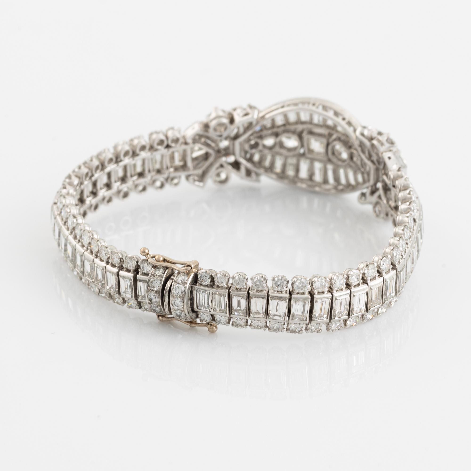 A platinum bracelet set with step-cut and brilliant-cut diamonds.