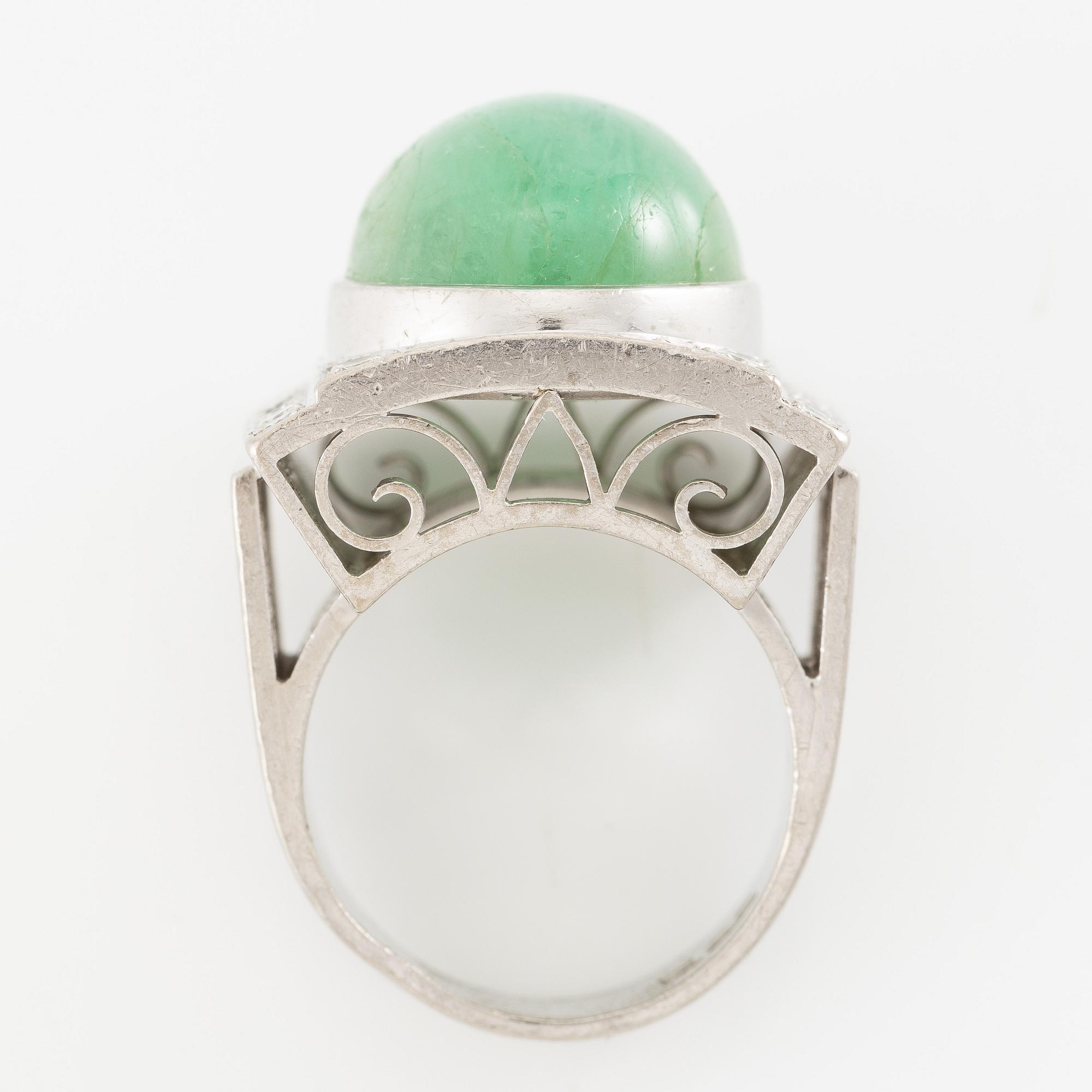 An 18K white gold ring set with a cabochon-cut emerald and round- and eight-cut diamonds.