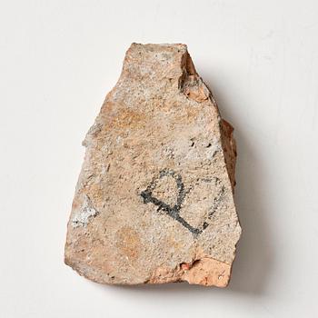 A presumably Hellenistic terracotta fragment, decorated in relief with an arm.