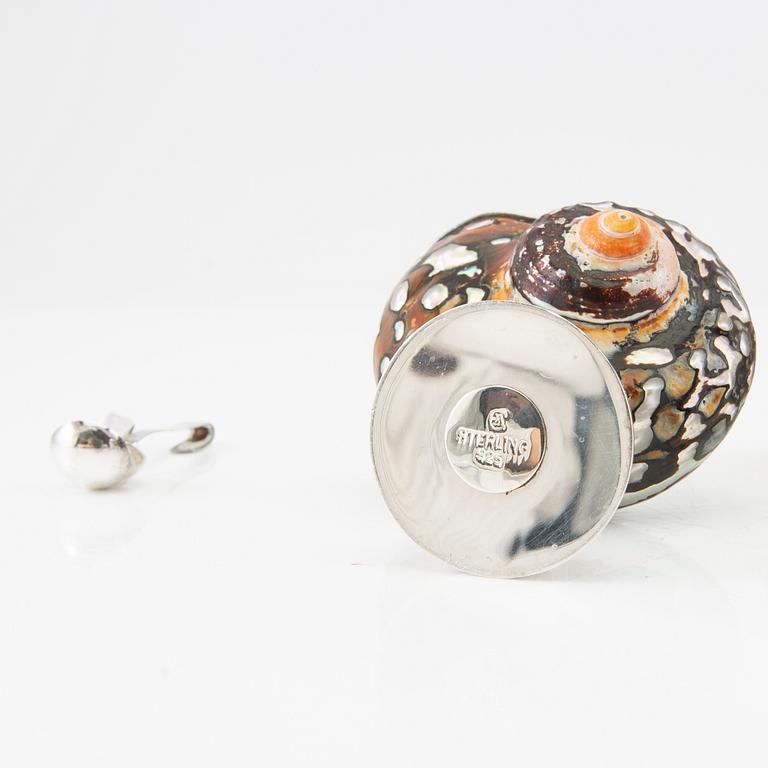 Salt and pepper shakers made of silver and shells.