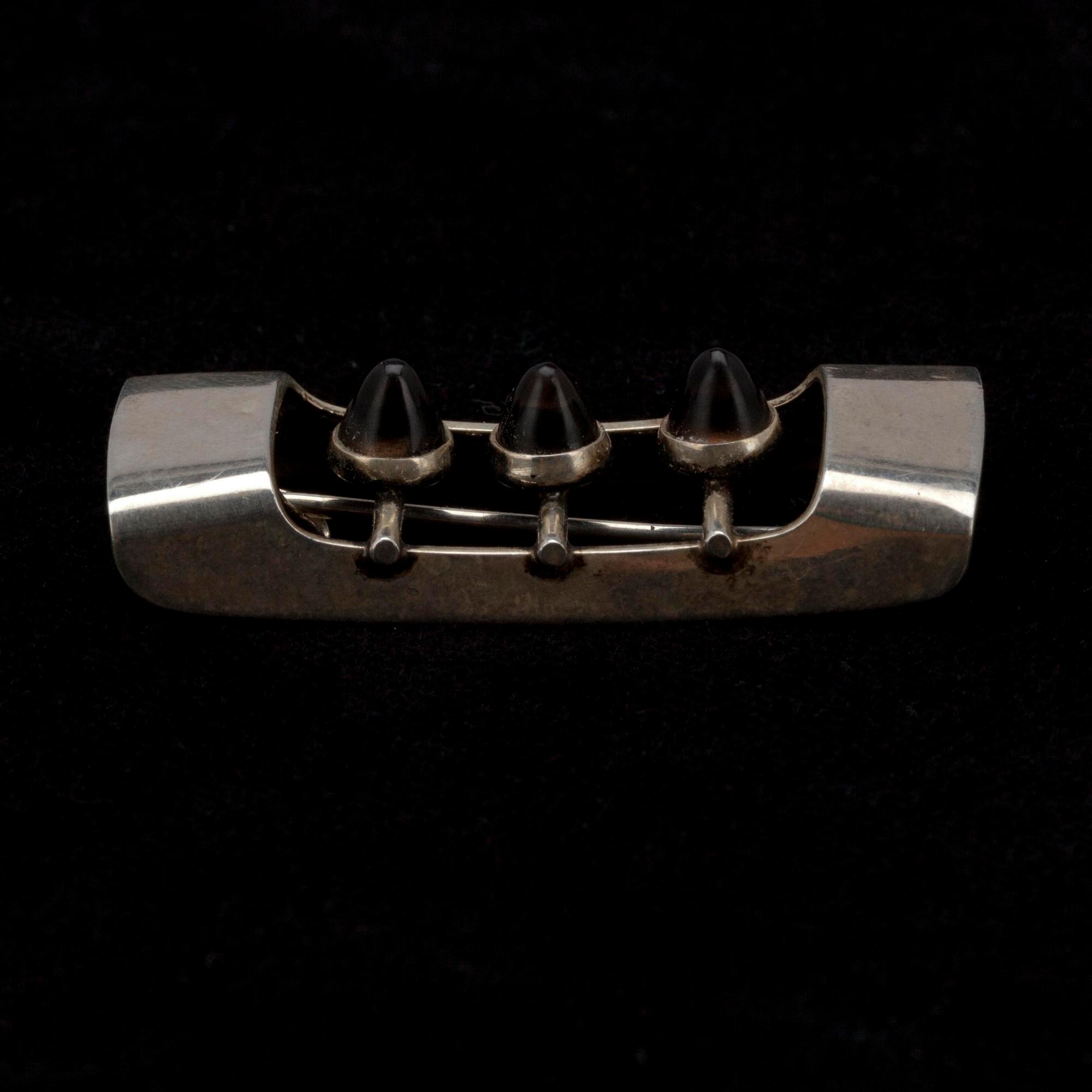 BROSCH, silver, cabochonslipade rökkvarts, design Elis Kauppi, Kupittaan Kulta, Åbo 1962. Vikt 6,8 g.