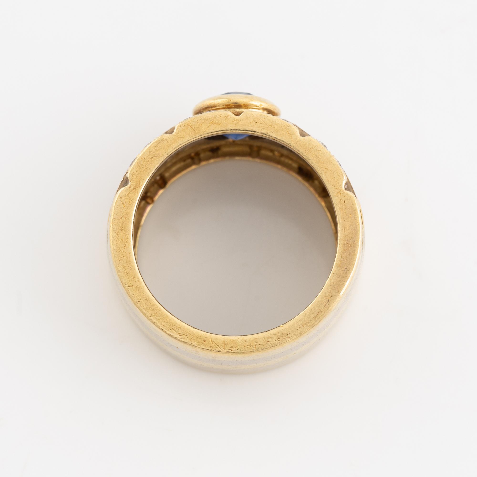 Ring 18K guld med en fasettslipad safir och runda briljantslipade diamanter.
