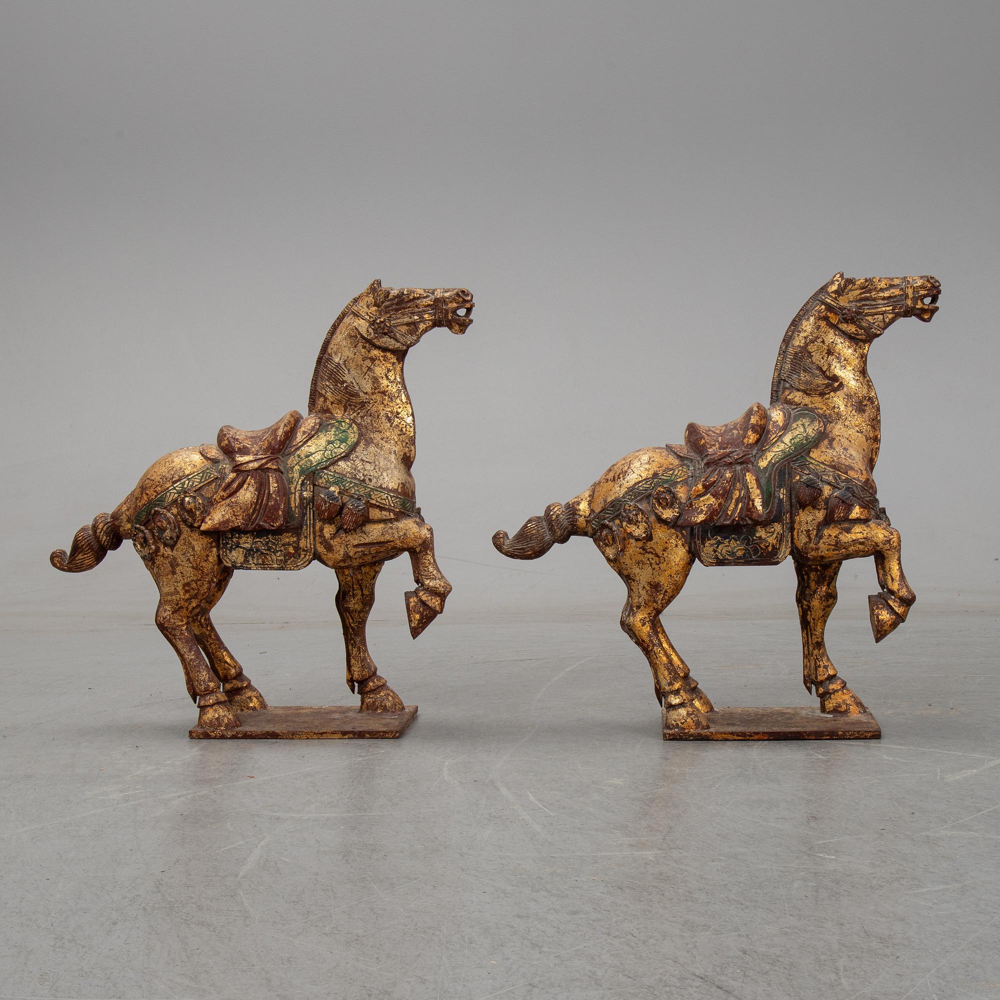 A pair of large Chinese wooden and gilt sculpture of horses, first half of the 20th century.