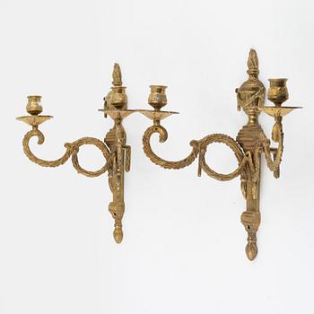 A pair of brass Louis XVI-style two-light wall lights, early 20th Century.
