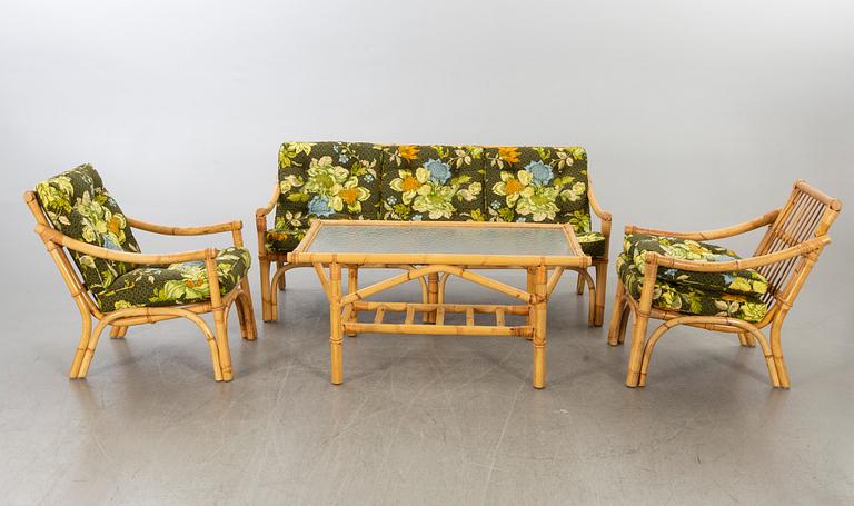 A set of ratten furniture, late 20th century; sofa, armchairs and a lounge table.